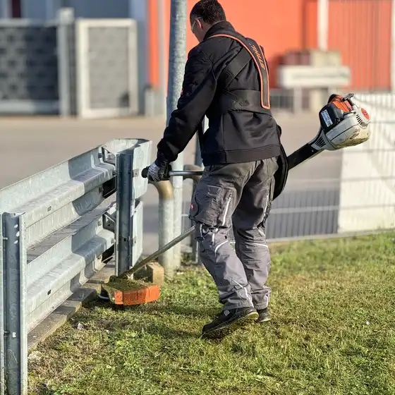 Ein Mitarbeiter beim Rasen trimmen