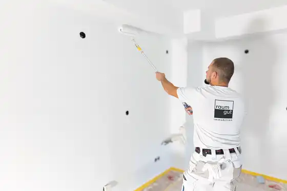 Ein Maler beim Streichen einer Wand