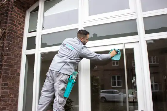 Ein Mitarbeiter von raumgut beim Reinigen einer Glasscheibe